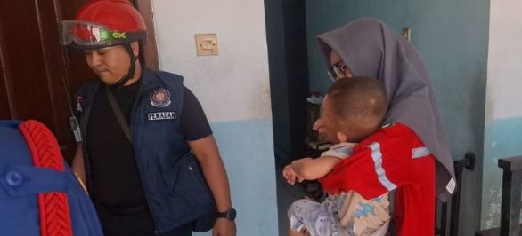 Petugas Damkarmat Gresik melakukan evakuasi balita yang terkunci di dalam kamar kos di Jalan Kramat Inggil, Gresik.